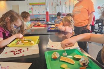 Children doing STEAM by looking for seeds from produce