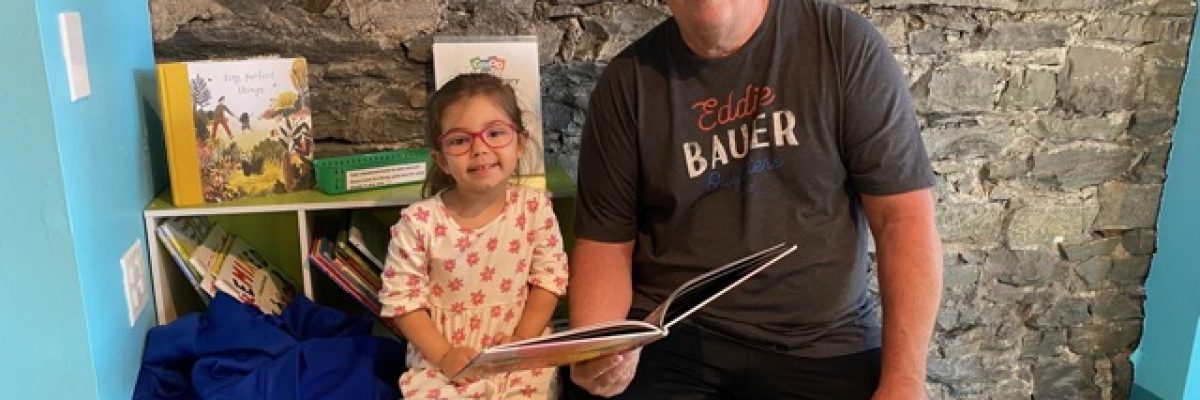 Adult with a child enjoying a book together