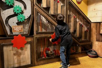 Child looking up at cider mill exhibit.